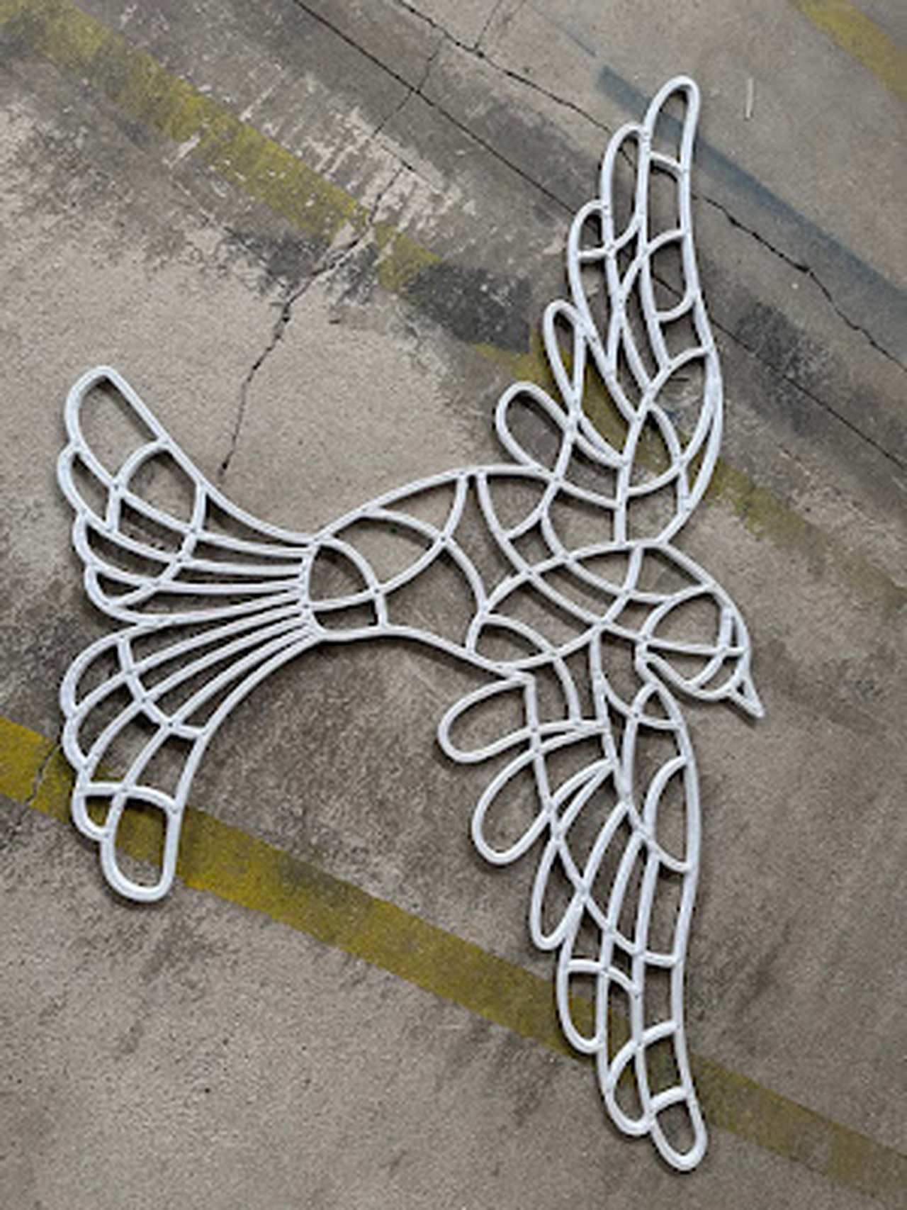 Detailní pohled na bílou konstrukci světelného ptáka s geometrickým členěním.